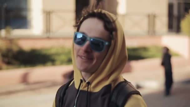 Snowboarder en lunettes de soleil marcher dans la rue et donner une interview en c — Video