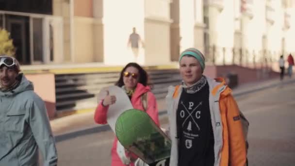 Os snowboarders andam na rua e dão a entrevista na câmera. Homens e... — Vídeo de Stock