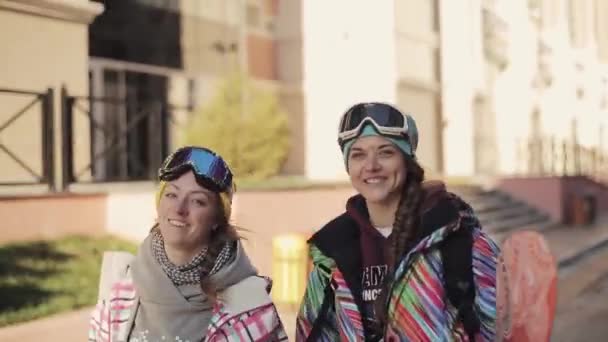 Dos niñas snowboarders caminar en la calle y dar entrevista en vino — Vídeo de stock