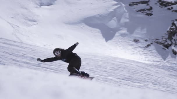 Χιονοδρομικό κέντρο. Snowboarder βόλτα στην πλαγιά, σπάζει απότομα. Σπρέι χιονιού. Τοπίο — Αρχείο Βίντεο