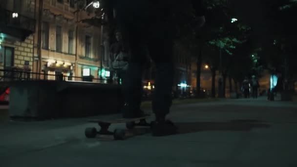 Skateboardista chlap v černým hoodie jezdí na nigth city park lane — Stock video