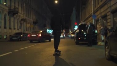 Siyah hoodie kaykaycı adam gece şehir caddede rides