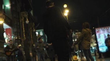 Siyah hoodie erkekte kaykaycı kalabalık gece şehir pav üzerinde sürmek