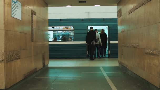 Люди идут в метро поезд на пустой станции, человек со скейтбо — стоковое видео