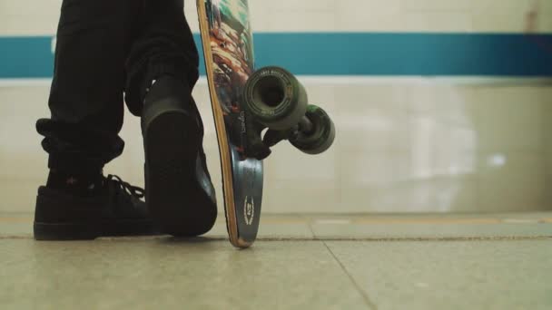 Σταυρωμένα πόδια του ανθρώπου με skateboard στέκεται στο σταθμό του μετρό — Αρχείο Βίντεο