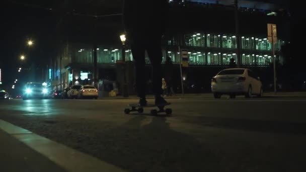 滑板男子在黑色帽衫骑在夜间城市道路附近的 b — 图库视频影像