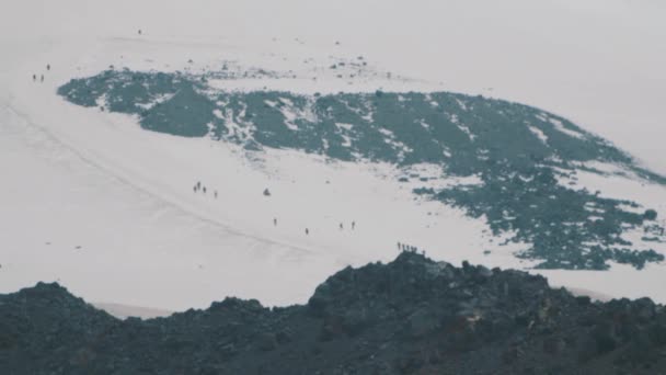 Personas escaladores turistas caminando en la ladera nevada alta montaña — Vídeo de stock