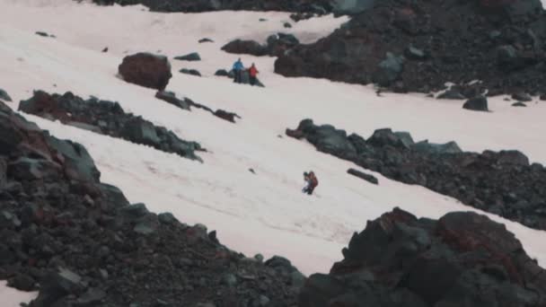 Extreme renner met snowboard klimmen op de berghelling — Stockvideo