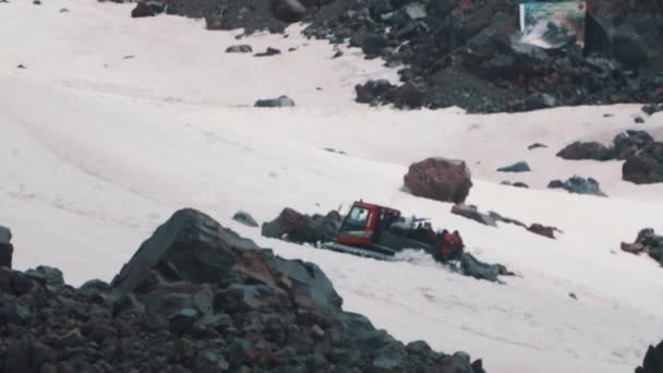 Schneekatze-Raupenmaschine mit Touristen fährt auf Berghang — Stockvideo