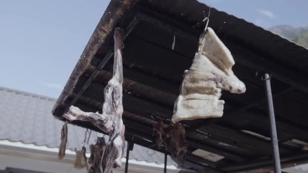 Jerky meat hanging under metal tile roof at mountain village — Stock Video