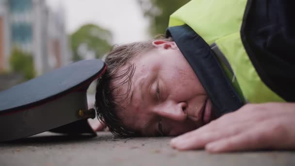 Εργαζόμενος αξιωματικός κυκλοφορίας ξυλοδαρμό και κουρασμένο ξαπλωμένη στο δρόμο — Αρχείο Βίντεο