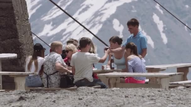 Grupo de turistas familiares cenando a la mesa en las montañas sendero camping — Vídeo de stock
