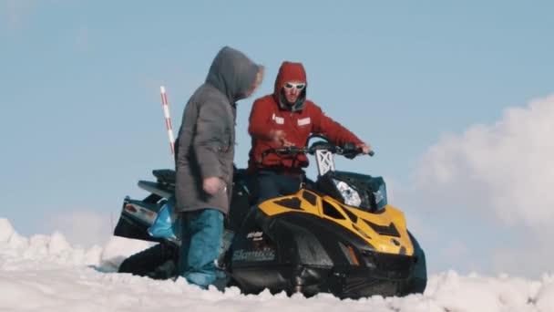 Två män med snöskoter talar på berget HANDTAGSREM — Stockvideo
