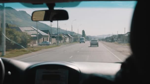 Naik mobil melalui desa pegunungan di jalan aspal — Stok Video