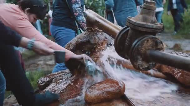 Gruppo di vecchia donna che beve acqua da tubo arrugginito a boschi — Video Stock