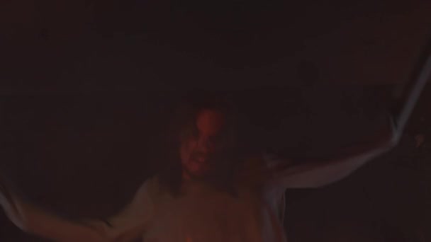 Šílený muž s rukávy vázána na strop zápasí v hořící opuštěné budovy — Stock video