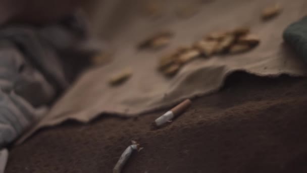Kaputte Zigaretten und Cracker auf Decke auf schmutzigem Sofa — Stockvideo