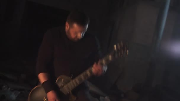 Muzyk mężczyzna agresywnie grać na gitarze rocka w opuszczonym budynku — Wideo stockowe