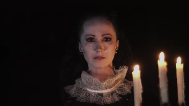 穿着维多利亚式连衣裙的妇女肖像站在烛台的黑屋子里 — 图库视频影像
