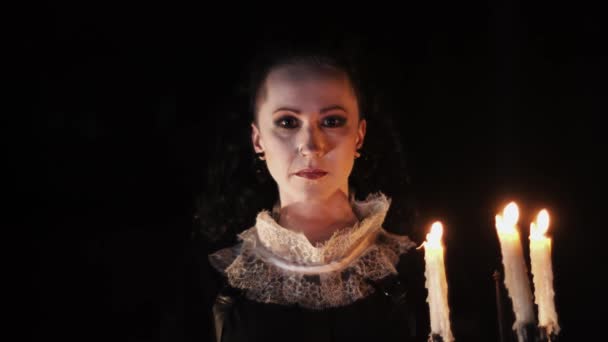 Mystieke vrouw in Victoriaanse jurk op zoek in de donkere kamer met kandelaar — Stockvideo