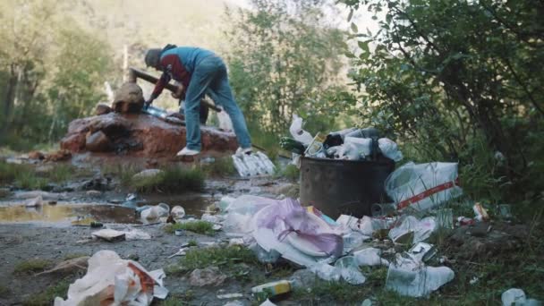 Hromada odpadků před kovovou trubkou pramen na lesní stezka — Stock video
