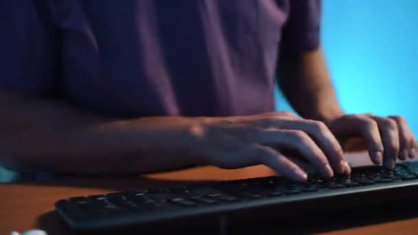 Kameran snurrar runt händerna på mannen som skriver på tangentbordet, plockar upp cigarett — Stockvideo