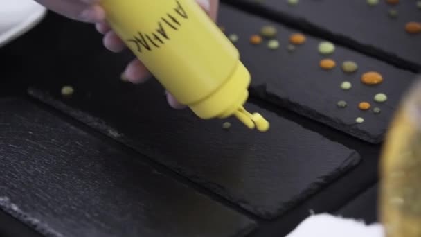 Decoración de placa rectangular negra poniendo gotas por botella de plástico amarillo — Vídeos de Stock