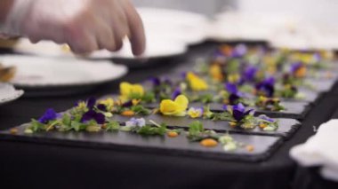 Üzerine küçük renkli çiçekler koyarak siyah dikdörtgen plakaların dekorasyonu