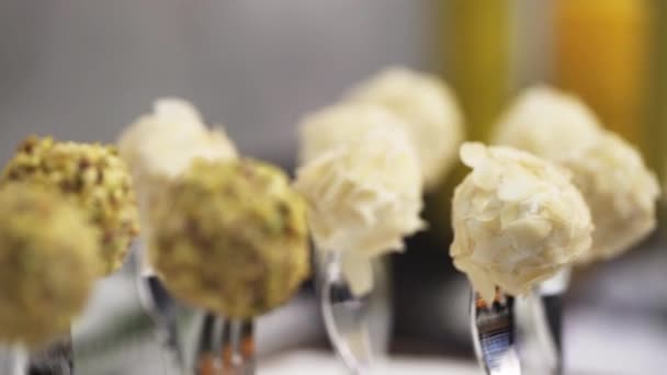 Closeup view of delicious balls put on silver forks on table for catering — Stock Video