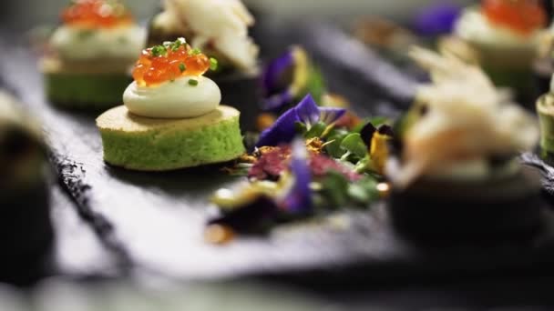 Detailní záběr lahodné a roztomilé vypadající canapes zdobené na stole pro catering — Stock video