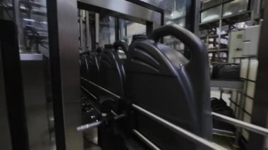 Fabrikada hareket eden taşıyıcıyla motor yağı doldurma görüntüsü.