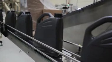 Fabrikada hareket eden taşıyıcıyla motor yağı doldurma görüntüsü.
