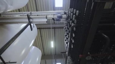 Borularla dolu büyük, modern bir fabrikanın iç manzarası. boru hatları ve diğer ekipmanlar
