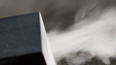 Dairesel testere kesikleri sırasında taştan yansıyan tahılların görüntüsü koyu granit bloğu keser.