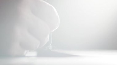 Sanatçının eli granit bloğun karanlık yüzeyine kum püskürtme yazısı yazıyor.