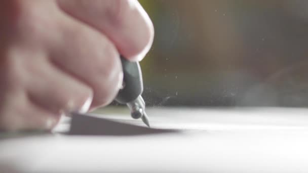 Macro of workers hand is sandblasting writing on dark surface of granite block — Stock Video