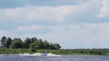Moskova, Rusya - 12 Temmuz 2019: Aktif erkek nehir boyunca giden tekneyi takip ederek su yüzeyinde süzülüyor