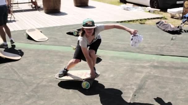俄罗斯莫斯科- 2019年7月12日：戴着绿色棒球帽的微笑女子站在平衡板上，看着镜头 — 图库视频影像