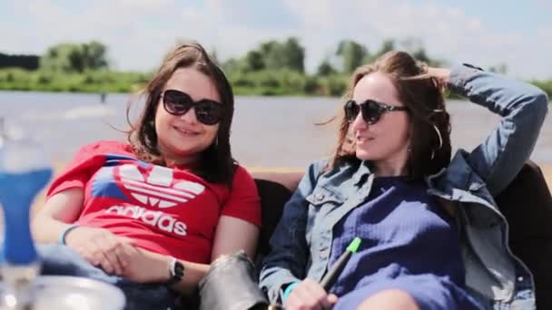 МОСКВА, РОССИЯ - 12 июля 2019 года: Две зрелые женщины в солнечных очках улыбаются и разговаривают на камеру в солнечный день . — стоковое видео