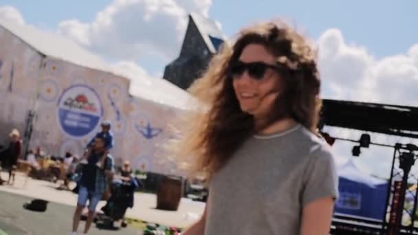 МОСКВА, РОССИЯ - 12 июля 2019 года: На доске баланса стоит красивая девушка в серой футболке с длинными волосами — стоковое видео