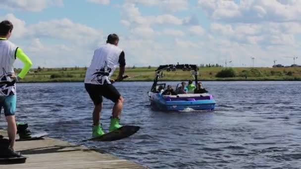 Moskau, russland - 12. Juli 2019: Motorboot entkommt, während reifer männlicher Wasserskifahrer zum Skifahren ins Wasser springt. — Stockvideo