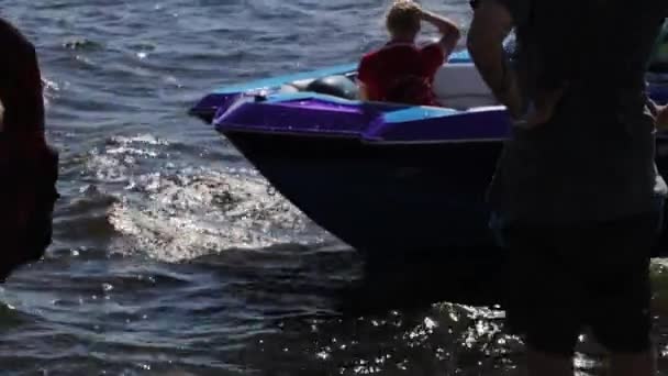 MOSCÚ, RUSIA - 12 de julio de 2019: Barco a motor violeta con mujer joven flota cerca del muelle lleno de gente en verano — Vídeo de stock