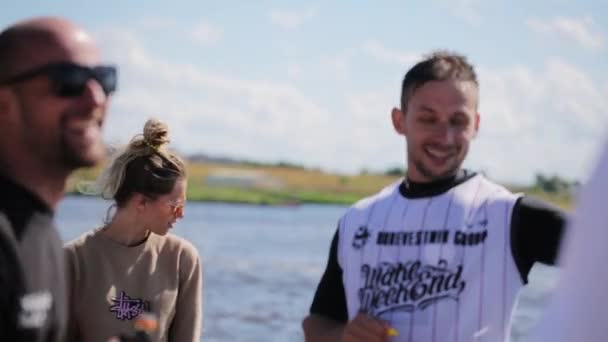 러시아 모스크바 - 2019 년 7 월 12 일: 화려 한 색상의 옷을 입은 귀여운 청소년들 이 인근의 강에 줄지어 있다 — 비디오
