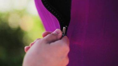 Moskova, Rusya - 12 Temmuz 2019: Şirin esmer kadın menekşe yüzme kostümünü fermuarlatıyor.