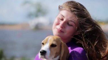 Moskova, Rusya - 12 Temmuz 2019: Menekşe mayo giyen güzel esmer kız şirin köpeği elinde tutuyor