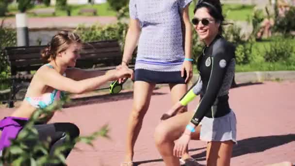 MOSCOW, RUSSIA - JULY 12, 2019: Three young attractive women are doing fitness exercises outside on sunny day — Stockvideo