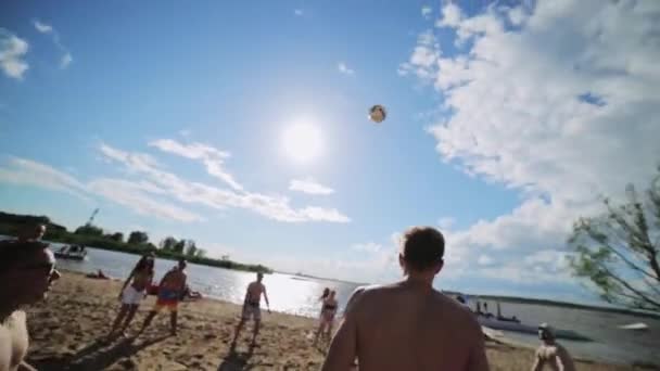 MOSCOW, RUSSIA - JULY 12, 2019: Group of young attractive people joyfully play valleyball on sunny summer beach — ストック動画