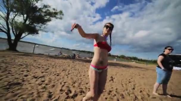 Moskova, Rusya - 12 Temmuz 2019: Sütyen ve iç çamaşırlı genç kız nehir kenarında yaz kumsalında dans ediyor — Stok video