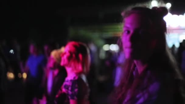 Moskva, Ryssland - 12 juli 2019: Söt flicka stirrar på något med glad blick, stående på utomhusfest. — Stockvideo