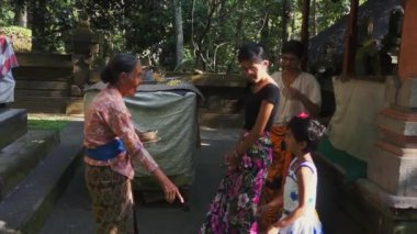 Bali, Endonezya - 22 Nisan 2018: Yerel giysili yaşlı kadın güneşli bir günde Asya köyünde genç bayanlarla konuşuyor